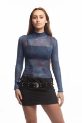 Top de cuello alto y manga larga confeccionado en tejido de malla semitransparente con estampado artístico abstracto en tonos azules. Presenta un diseño ajustado al cuerpo.