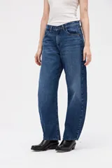 Jean de tiro alto con silueta tipo globo, ajustado en la cintura y con piernas holgadas que se estrechan hacia el bajo.