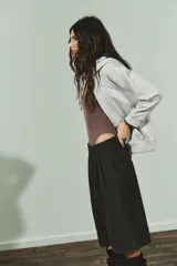 Body de manga larga con cuello redondo, confeccionado en una mezcla de algodón y modal. Presenta cierre inferior con botones a presión.