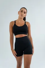 Top deportivo negro de breteles finos cruzados en la espalda, con diseño ajustado y escote redondo.