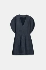 Vestido corto de denim con escote en pico, mangas cortas abullonadas con aberturas y costuras con pespuntes a contraste. Cierre posterior con cremallera.