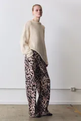 Jeans de tiro medio con diseño de cinco bolsillos, cierre frontal con cremallera y botón, y cintura con trabillas. Presenta un corte recto y largo completo con estampado animal print.