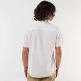 Camisa blanca de manga corta y cuello mao, con cierre frontal de botones con efecto carey y diseño en mezcla de lino.