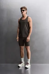 Musculosa deportiva de running en tejido ligero y perforado de color marrón, con cuello redondo y diseño sin mangas.