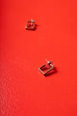 Aros de diseño cuadrado con estructura de metal dorado y bordes rectos, con cierre de presión.
