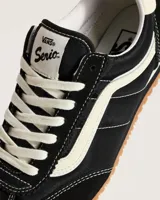 Championes Vans modelo Super Lowpro, de perfil bajo inspiradas en el diseño Serio. Presentan una combinación de ante y material sintético en color negro con detalles en blanco, incluyendo la icónica Sidestripe lateral, cordones blancos y suela de caucho con diseño Waffle.