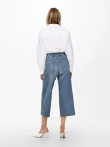 Jean de corte wide leg y tiro alto, con diseño cropped y terminación deshilachada en el ruedo. Confeccionado en denim elástico con cinco bolsillos y cierre frontal con botón metálico.