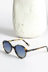 Lentes de sol redondos con montura carey y lentes degradados azules.