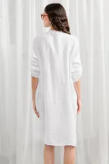 Túnica de lino color verde oliva, con cuello mao, cierre frontal con botones, bolsillos en el pecho y mangas largas con detalle de ajuste.