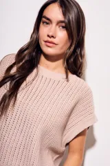 Chaleco sin mangas de tejido de punto color rosado pálido, con textura calada y acabado lurex, corte al cuerpo y cuello redondo.