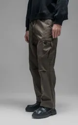 Pantalón cargo de corte regular confeccionado en textil técnico pesado color chocolate. Presenta cintura elástica con cordón de ajuste, dos bolsillos laterales en la cintura y dos bolsillos cargo de gran tamaño. Incluye elásticos con tancas en los tobillos para regular la apertura de la pierna.