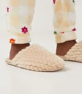 Pantufla cerrada de mujer con textura de peluche suave en color negro, diseñada para brindar comodidad en el hogar.