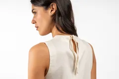 Vestido corto de lino en color beige, con escote en V y diseño sin mangas de corte recto y holgado.