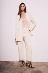 Blazer color crema de poliéster y viscosa, de corte oversize con solapas y doble botonadura.