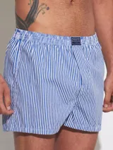 Bóxer de algodón blanco con estampado de flores pequeñas color celeste, con cintura elástica y logo de la marca en el centro.