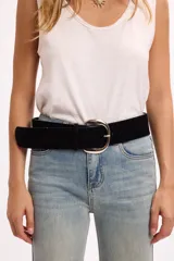 Cinto de gamuza negra con hebilla metálica plateada de diseño redondeado.