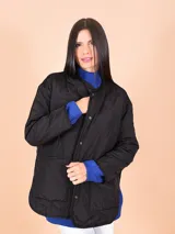 Campera negra matelaseada con cuello mao y cierre con botones a presión. Tiene bolsillos laterales y corte holgado.