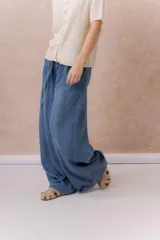 Jean de calce amplio y relajado, color azul, con pierna extra ancha y caída fluida. Diseño de tiro alto con pinzas delanteras y lazo regulable en la cintura. Cuenta con bolsillos laterales y traseros.