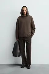 Sudadera tipo hoodie de corte relajado, confeccionada en tejido de algodón con interior de rizo. Presenta cuello con capucha, manga larga y acabados con bordes enrollados.