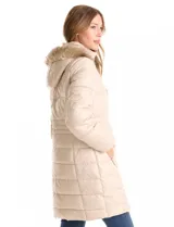 Campera puffer larga con diseño capitoneado, cierre frontal completo, bolsillos laterales con cierre y capucha desmontable con borde de piel sintética.