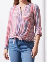 Camisa de gasa estampada a rayas verticales en tonos rosa, naranja, celeste y blanco. Tiene cuello a la base con escote en V y abertura central con botones. Cuenta con un bolsillo aplicado en el pecho, mangas largas regulables con presilla y botón, y terminación opcional de nudo en el ruedo.