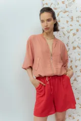 Campera estilo bomber color salmón, confeccionada en tela texturizada, con cierre frontal y bolsillos delanteros.