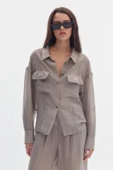 Camisa gris de efecto sedoso, manga larga, con cuello clásico, cierre frontal con botones y bolsillos delanteros con solapa y bordado.