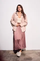 Camisa color marrón de gamuza sintética, de corte recto, con cuello clásico, cierre frontal con botones y mangas largas.