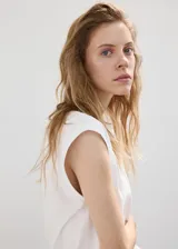Camiseta blanca de algodón con hombreras, cuello redondo y diseño recto sin mangas.