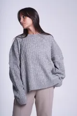 Sweater oversize tejido en punto trenzado color gris, con cuello redondo y mangas largas.