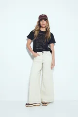 Remera negra de manga corta con estampado frontal en color marrón que incluye ilustraciones relacionadas con el café y la frase "Start Your Day Right".