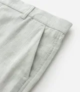 Bermuda de hombre en lino color gris claro, de corte recto, con textura discreta, bolsillos laterales y cierre frontal con botón y cremallera.