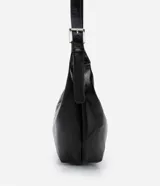 Bolso modelo hobo de gran tamaño, confeccionado en poliuretano con acabado que imita el cuero. Presenta una forma de media luna, cierre superior con cremallera y una correa de hombro ajustable con hebilla metálica.