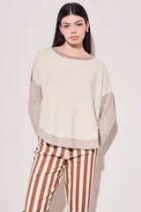 Sweater beige con mangas y cuello en color topo.
