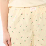 Conjunto de pijama de dos piezas compuesto por una remera de manga corta color amarillo claro con pequeño estampado en el pecho, y un short amarillo con estampado de rayas verticales y cerezas, con elástico en la cintura.
