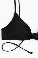 Top de bikini negro con breteles finos ajustables y nudo decorativo en el centro del busto.