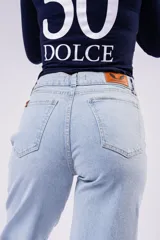 Pantalón de jean corte wide leg en color celeste claro, con tiro medio y diseño de pierna ancha. Presenta cierre frontal con botón y bolsillos laterales.