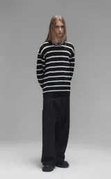 Sweater de cuello redondo con diseño de rayas horizontales en blanco y negro. Confeccionado en tejido de punto con textura suave, corte oversize y terminaciones en punto rib en cuello, puños y ruedo.