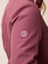 Campera softshell blanca con cierre frontal completo, cuello alto y bolsillos laterales. Presenta un bolsillo vertical con cierre en el pecho y el logo de la marca bordado.