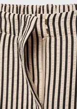 Pantalon de corte recto con estampado de rayas verticales, tiro medio y detalle de pinzas delanteras. Cuenta con cierre frontal de botón, gancho y cremallera, además de trabillas para cinturón y bolsillos laterales.
