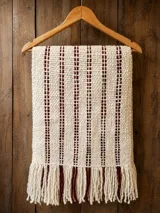 Pashmina de lana merino, tejida a mano, en color crudo con rayas verticales bordó y flecos en los extremos.