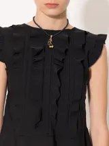 Top negro de lycra doble bifaz con mangas japonesas y escote en la espalda. Presenta detalles fruncidos en el delantero y cintura con volado caracol. Se accede mediante tiras en la espalda superior y un cierre desmontable.