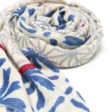 Pashmina de textura suave con estampado geométrico y floral en tonos azules sobre fondo beige, con detalles de líneas rojas en los bordes.