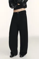 Jeans de corte baggy y tiro medio en color negro. Presenta diseño de cinco bolsillos y detalle de cremalleras verticales en el frente de las piernas con efecto torcido.