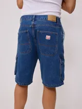 Bermuda de jean azul con bolsillos cargo laterales y corte a la rodilla.