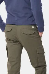 Pantalón cargo azul marino con bolsillos laterales con solapa y cinturón de cuero marrón.