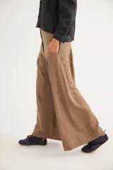 Pantalón de tiro alto en color azul, con cierre frontal de tres botones, pinzas en la cintura y corte holgado.