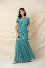 Vestido largo de tul verde con bordado floral al tono, corte sirena y mangas cortas.