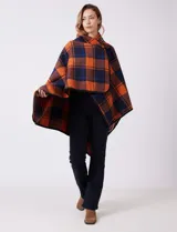 Capa de tejido cuadrille con diseño de cuadros en tonos marrón, beige y naranja. Presenta un cierre frontal con botón tipo trenca y bordes con ribete negro.