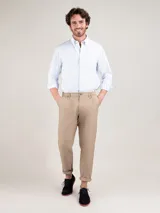 Camisa de hombre con diseño de rayas finas celestes y blancas, corte regular fit, cuello button down y manga larga. Cuenta con cierre frontal de botones y sutil logo bordado en el pecho.
